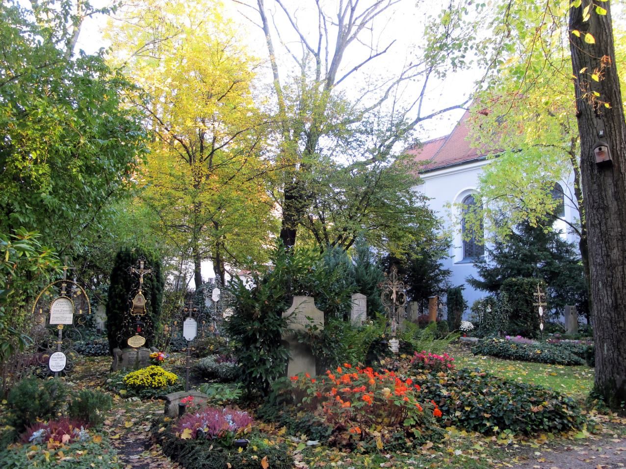 Gräber und herbstliche Bäume am Friedhof Bogenhausen neben St. Georg